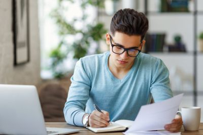 Photo d'un jeune indépendant signant un contrat pour transformer son activité en société.