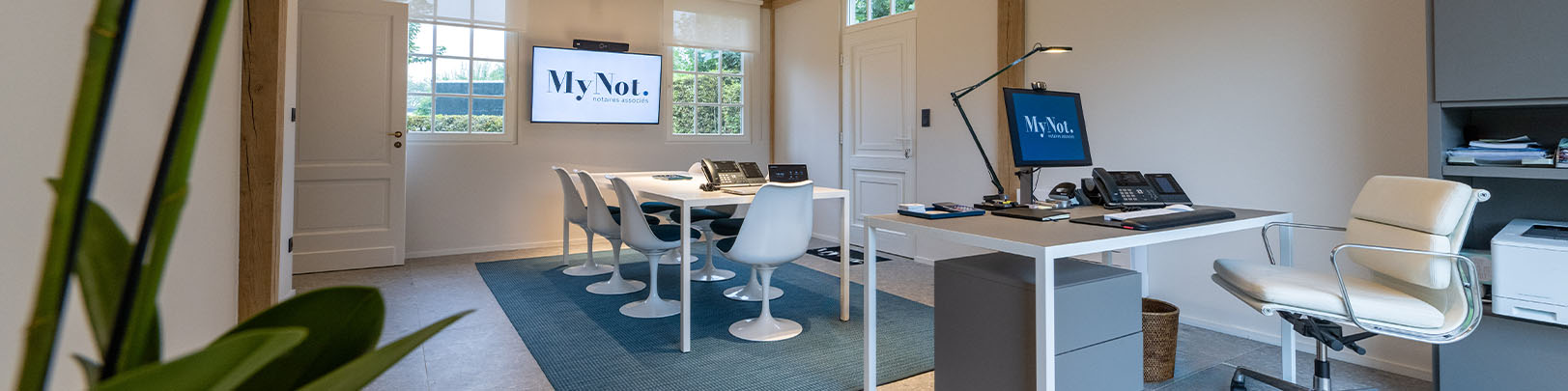 Bureau de notaire avec un ordinateur et des fournitures de bureau.